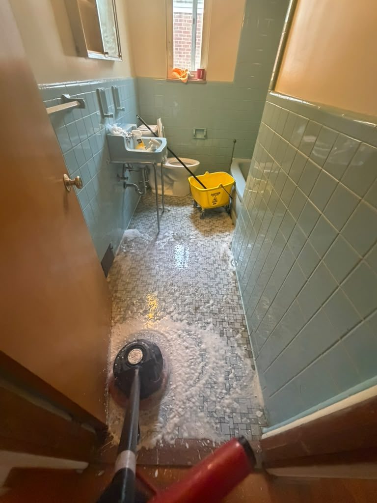 Bathroom floor being mopped and scrubbed